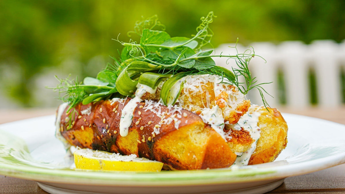Knuspriger Fisch-Hotdog mit Parmesan, Dill-Mayo & kurz eingelegter Gurke