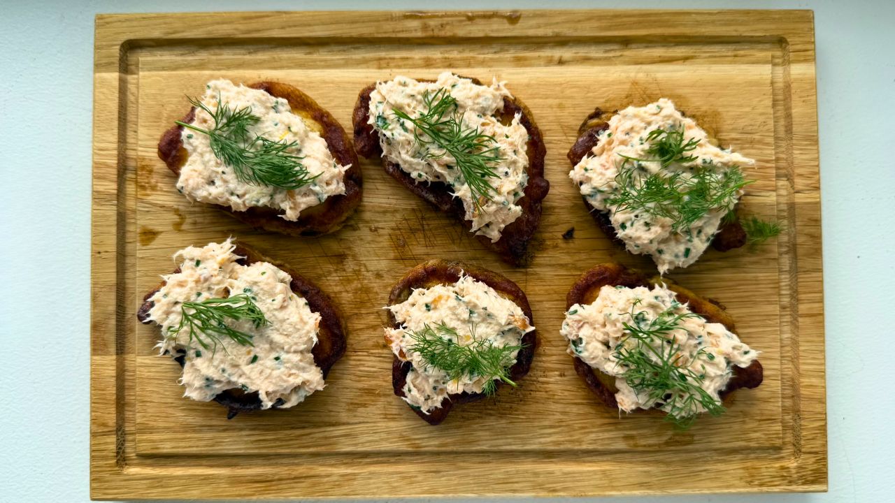 Kartoffelblinis mit Räucherlachsmousse, eingelegter Gurke und Roggenbrot-Crunch