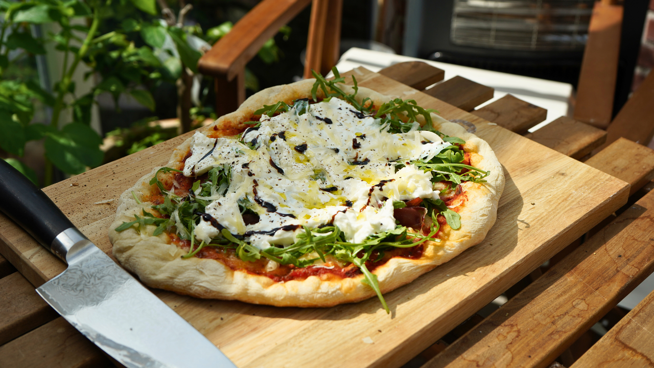 Pizza mit Parmaschinken, Rucola und Burrata