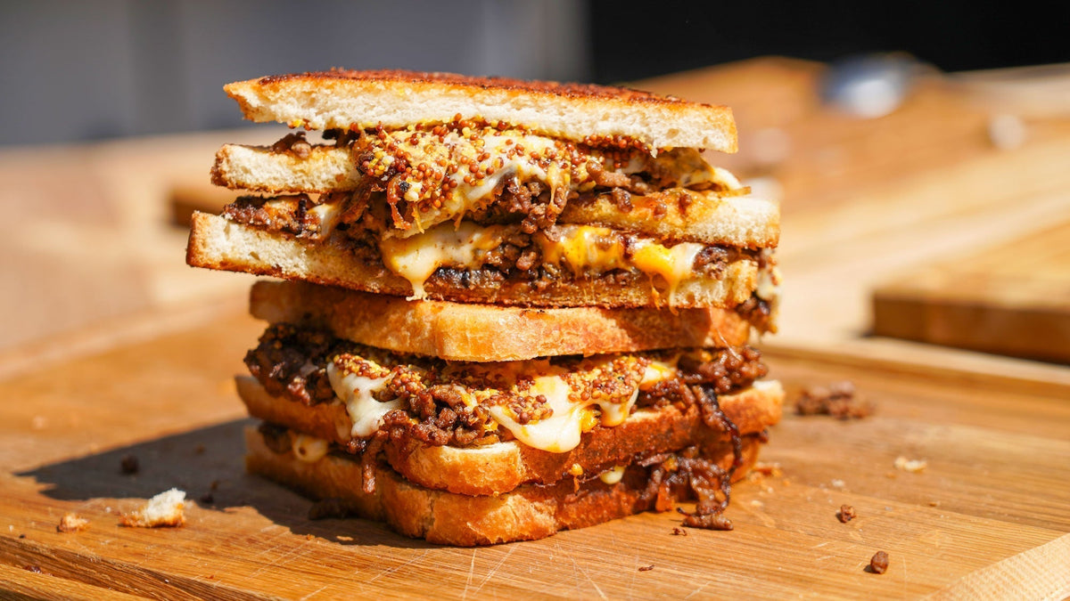 Cowboy-Toast mit Rindfleisch, geschmorten Zwiebeln & Käse von der Grillplatte