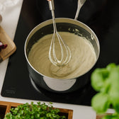 Aufgeschlagene Sauce béarnaise im Stieltopf auf dem Herd