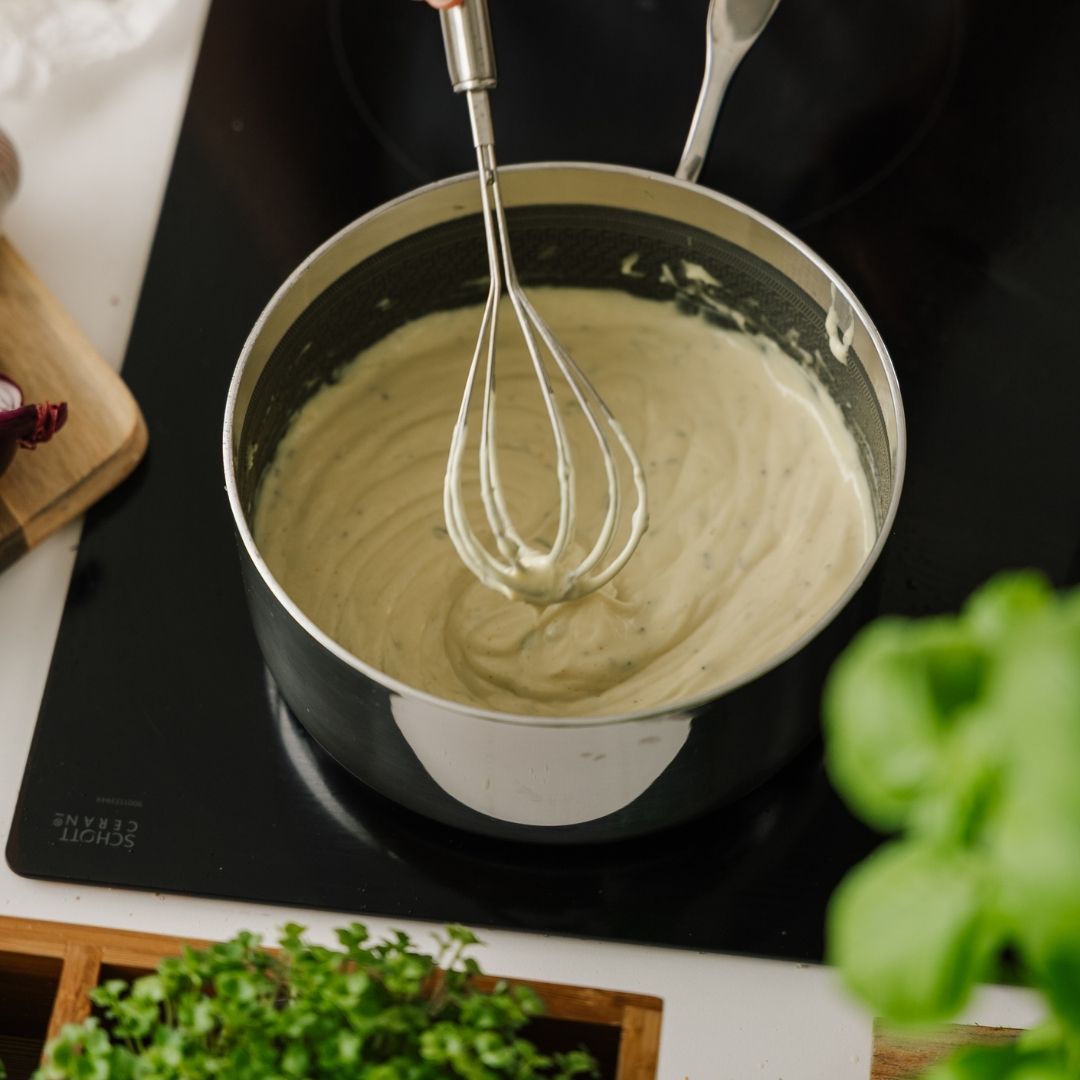 Aufgeschlagene Sauce béarnaise im Stieltopf auf dem Herd