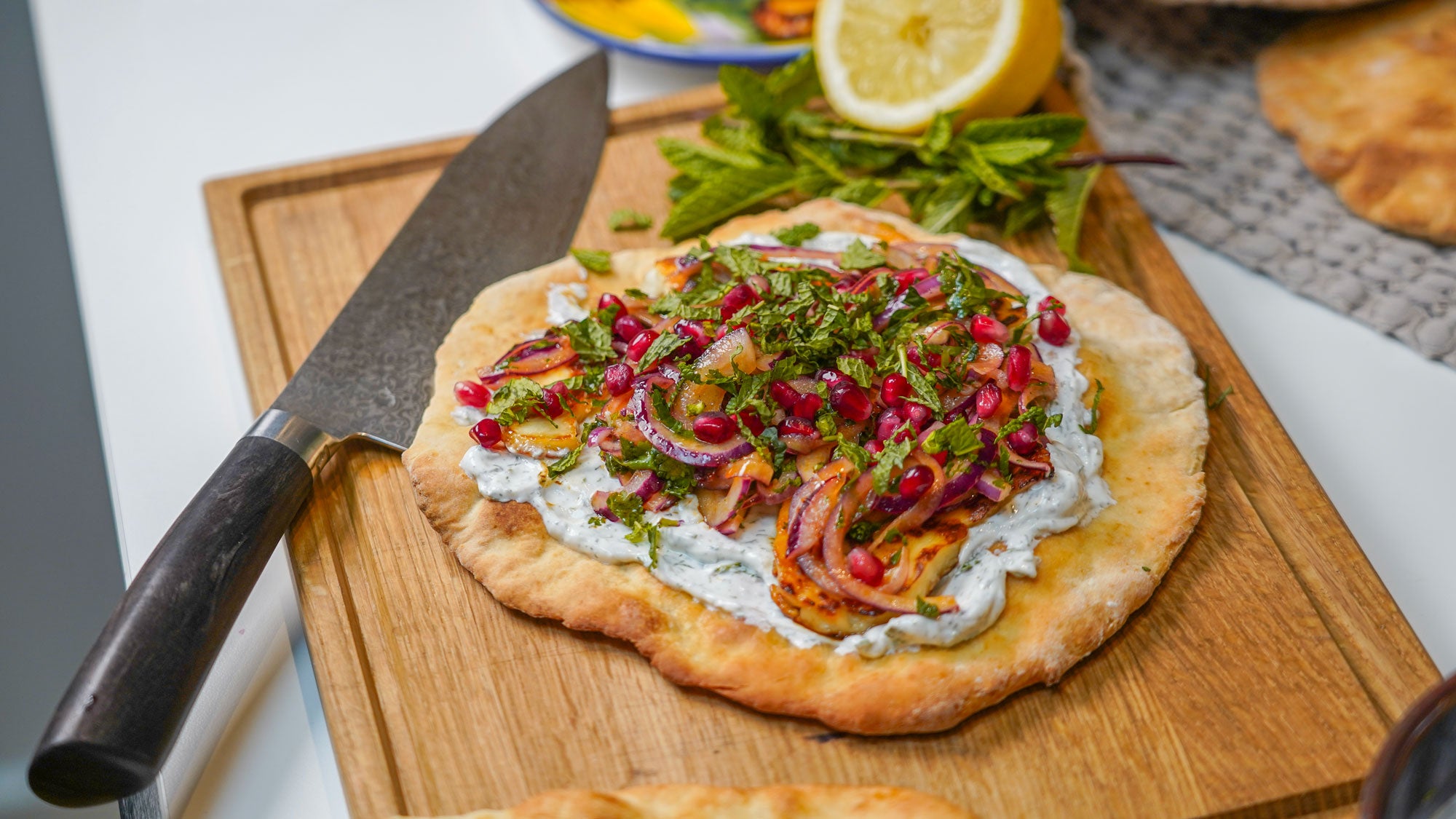 Hausgemachte Fladenbrote mit Halloumi, zitronenmarinierten roten Zwiebeln & Joghurtdressing