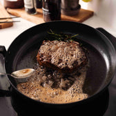 Steak beim Braten in einer Carbonstahl-Pfanne 