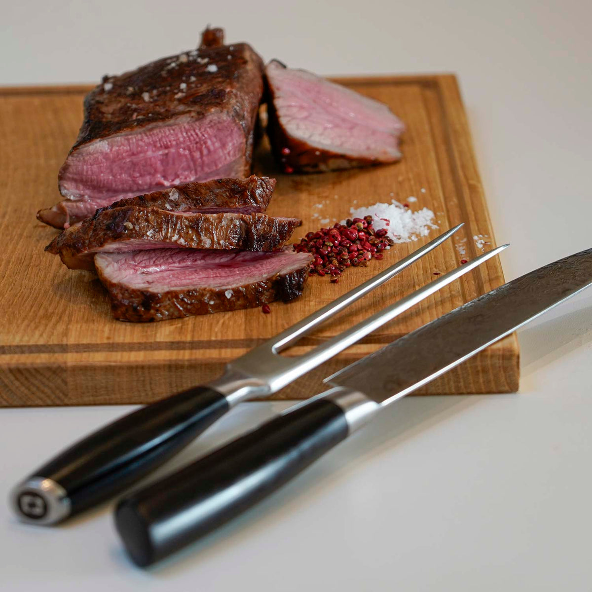 Tranchierset auf einem Schneidebrett mit Fleisch in stimmungsvollem Ambiente
